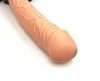 Pohled zblízka na realistický žalud dutého strap-on penisu v tělové barvě.